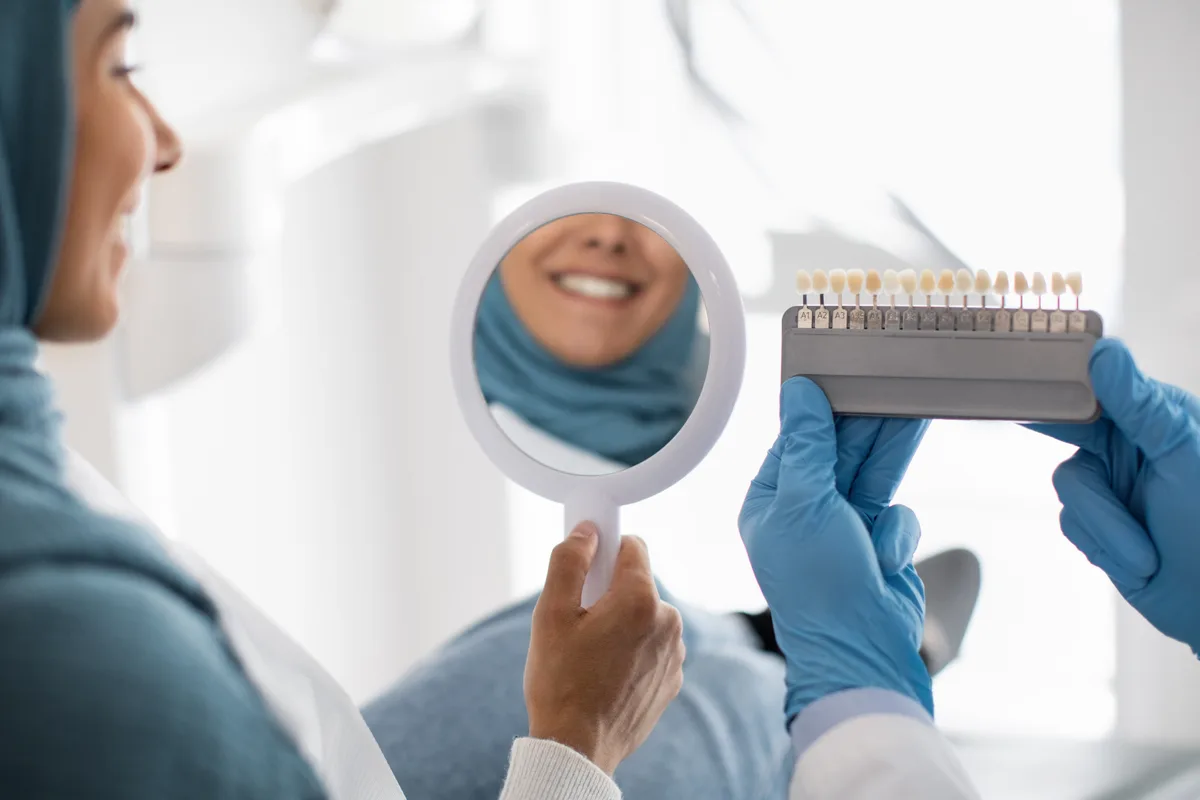 Patient checking smile in mirror after a whitening session