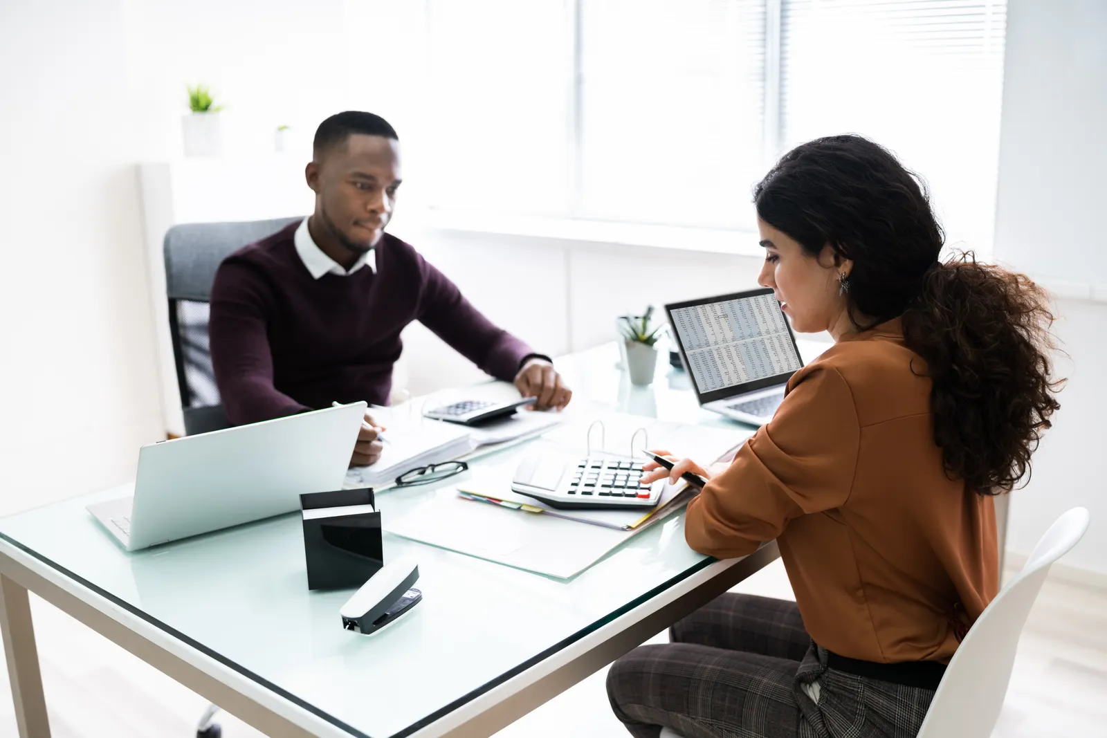 Accountant working through numbers with a client at a desk