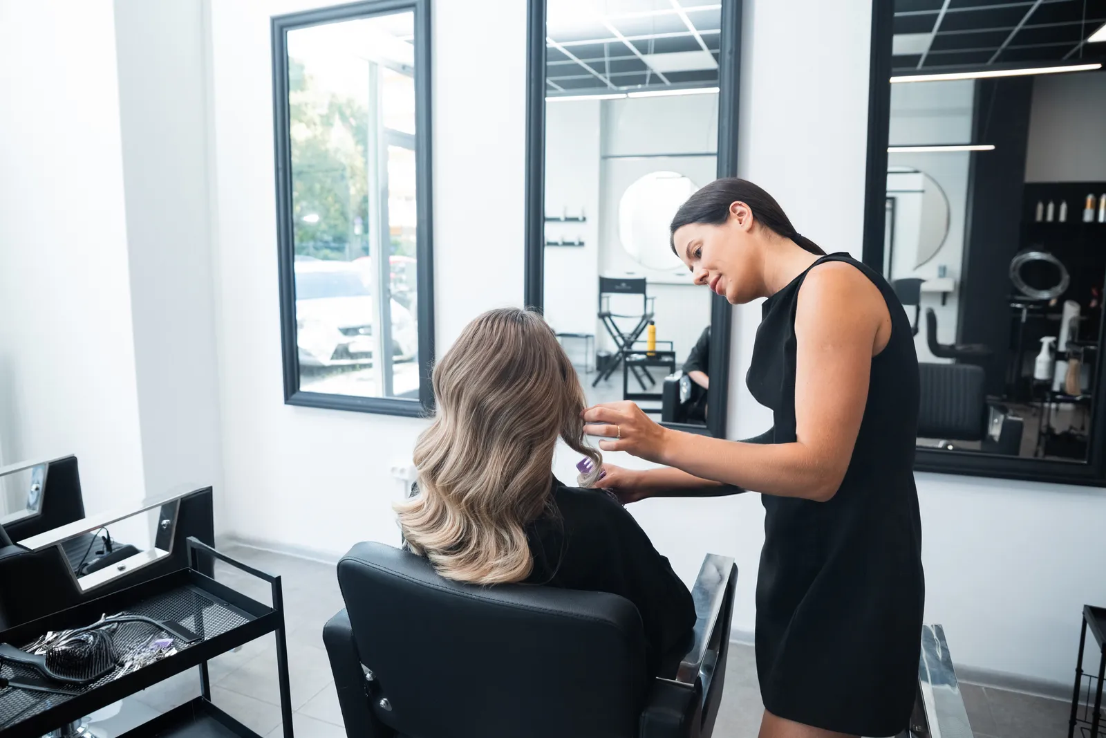 Stylist working on a client's hair in a modern salon