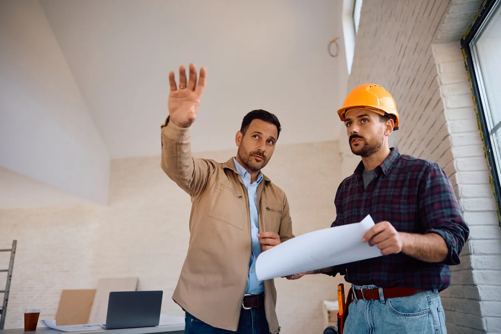 Two builders reviewing plans on a job site