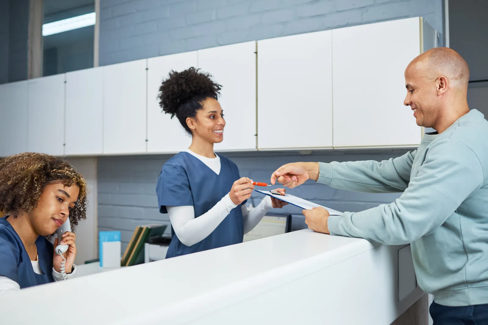 Dental receptionist checking in a patient at the front desk
