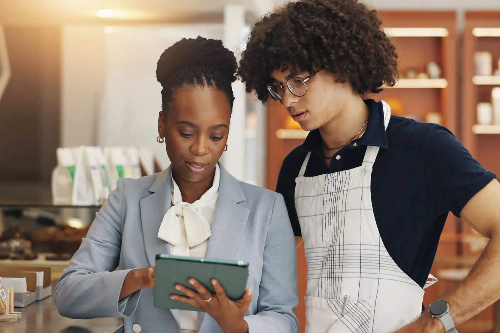 Franchise advisor reviewing a tablet with a local shop owner