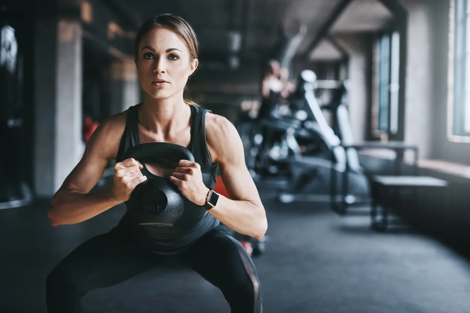Gym members lifting weights side by side on their club's strength floor