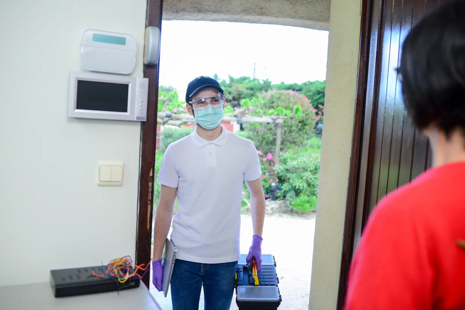 Technician arriving at a customer's door with a toolbox