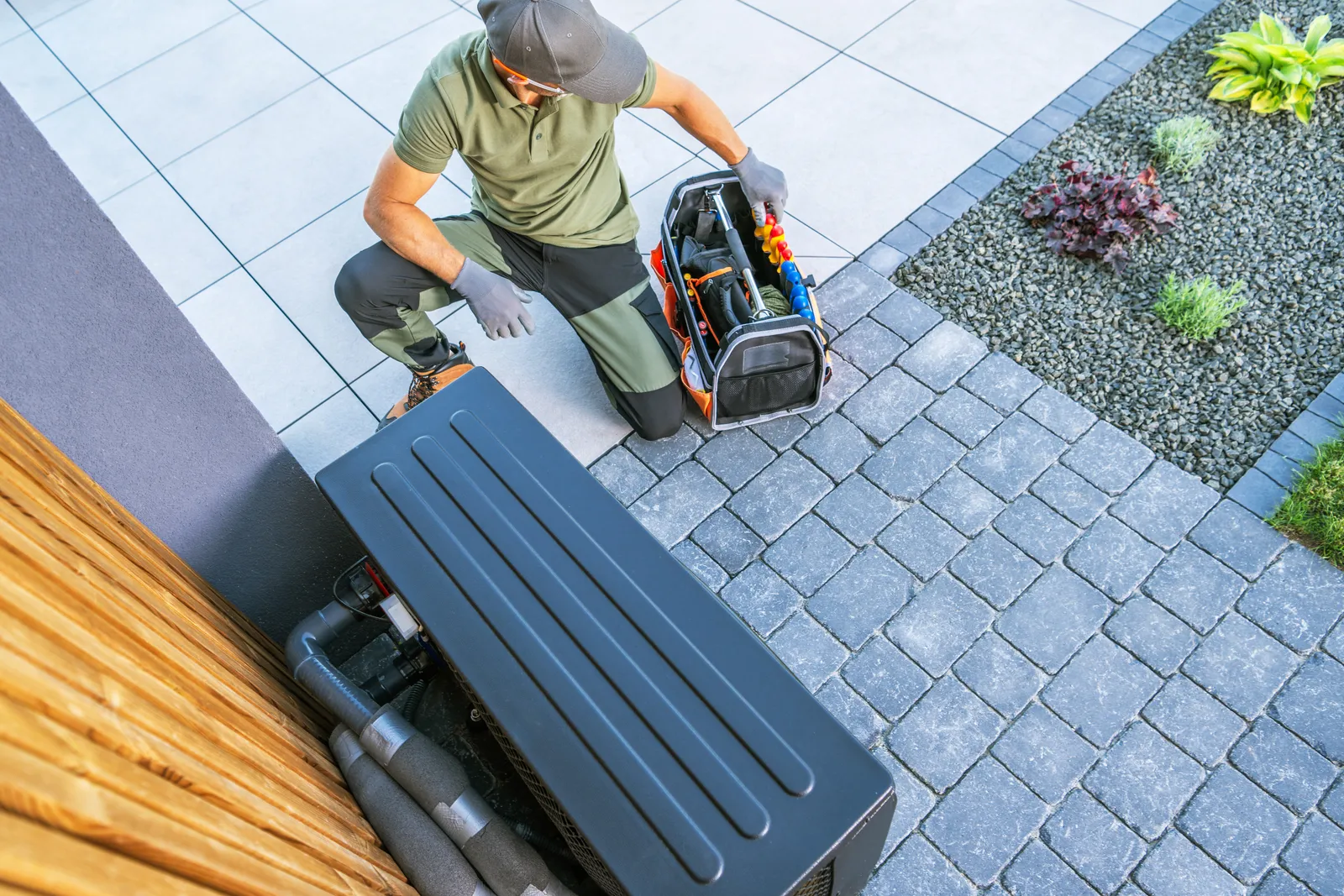 HVAC technician servicing equipment outside a home