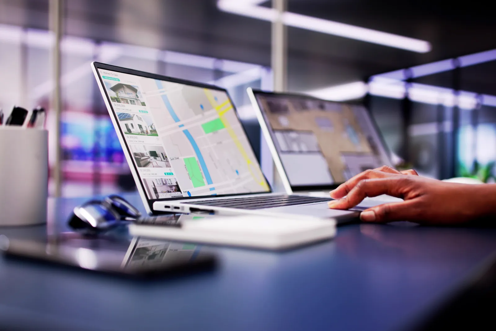 Laptops showing multi-location map dashboards side by side