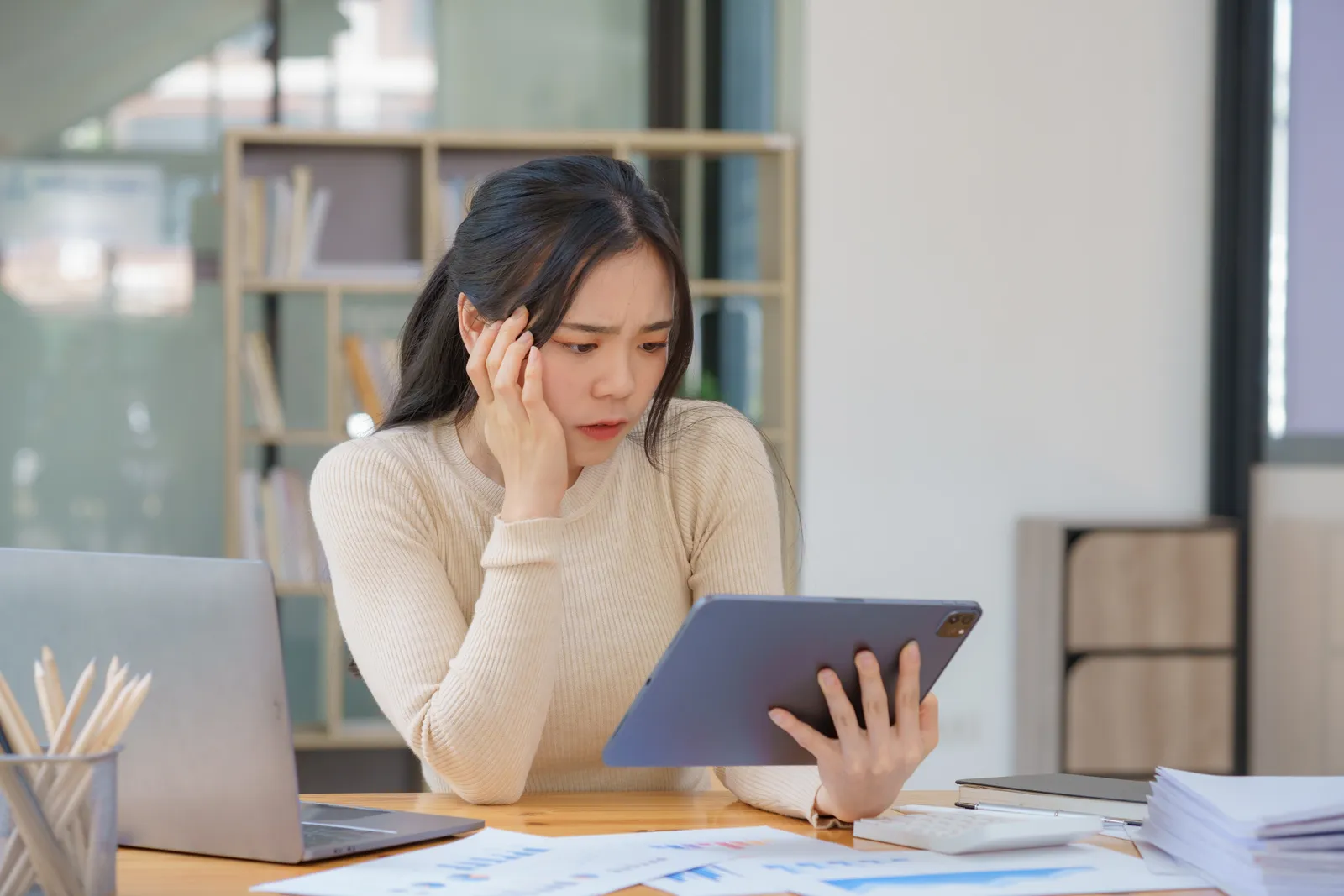 Business owner unimpressed by her agency's report at her desk