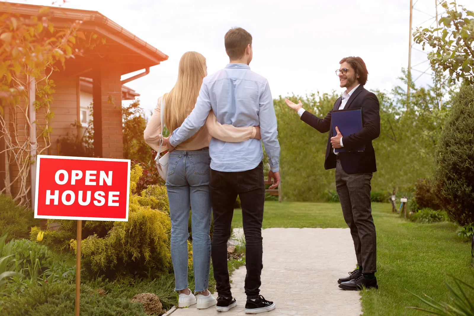 Agent walking a couple past an open-house sign