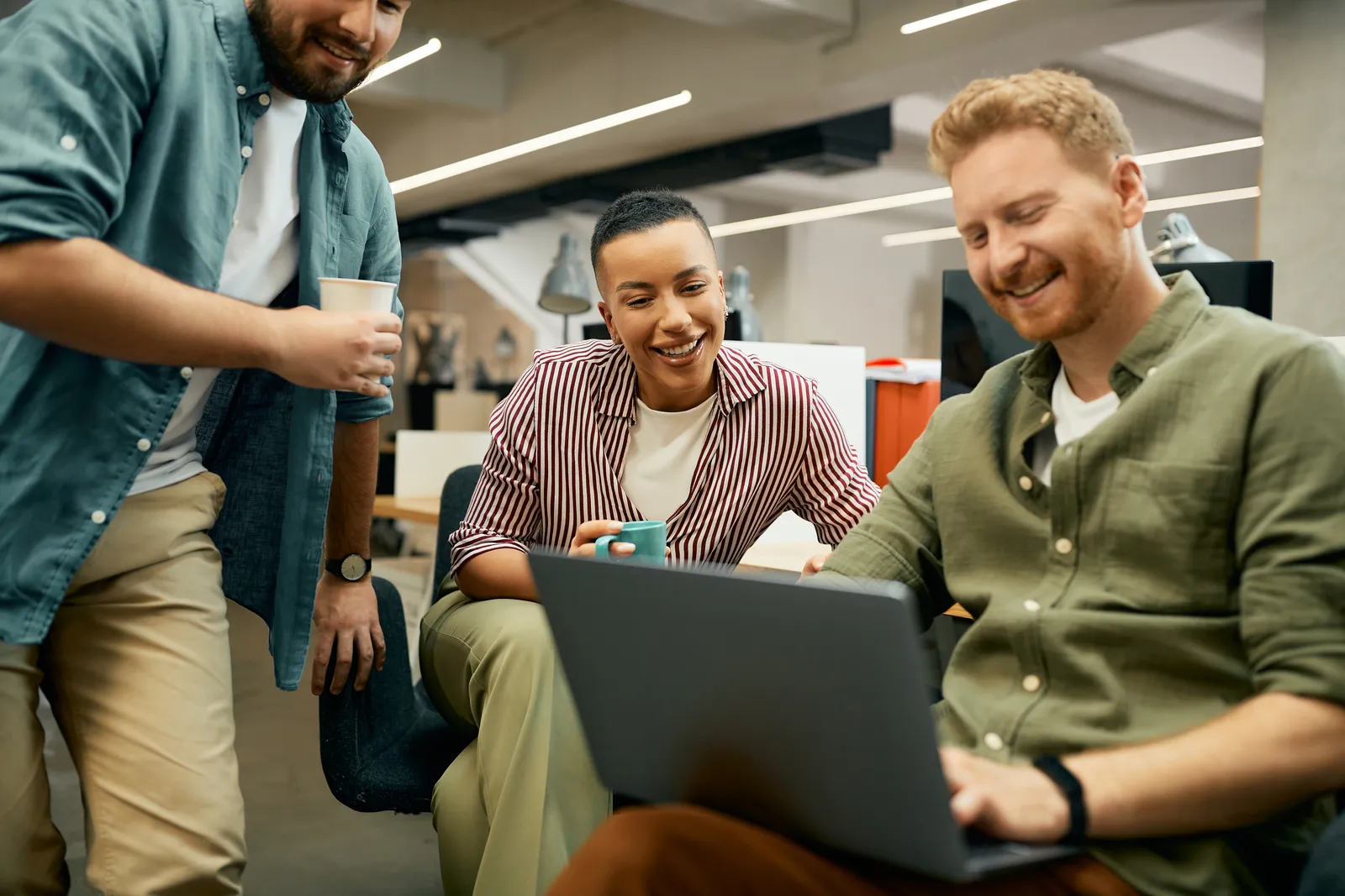 Startup team gathered around a laptop in their office