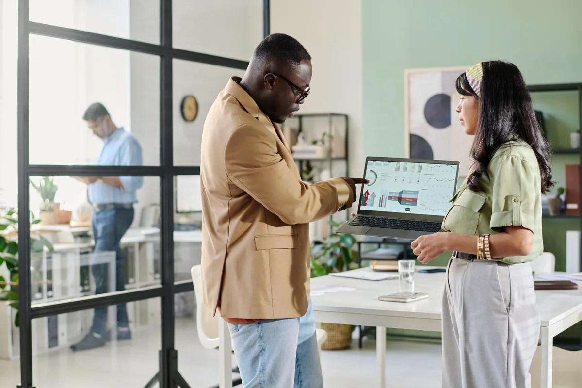 An e-commerce marketing team reviewing Shopify store performance and email campaign metrics together on a laptop