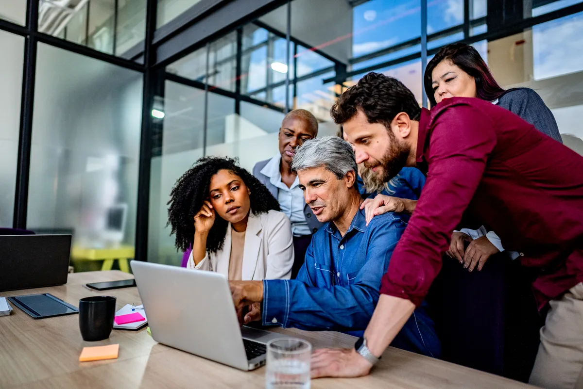 A small sales team reviewing their CRM pipeline together on a laptop in a bright office