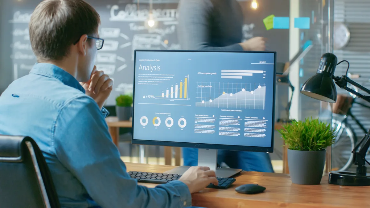A digital marketing specialist reviewing backlink and referral-traffic data on a desktop monitor while planning AI search strategy