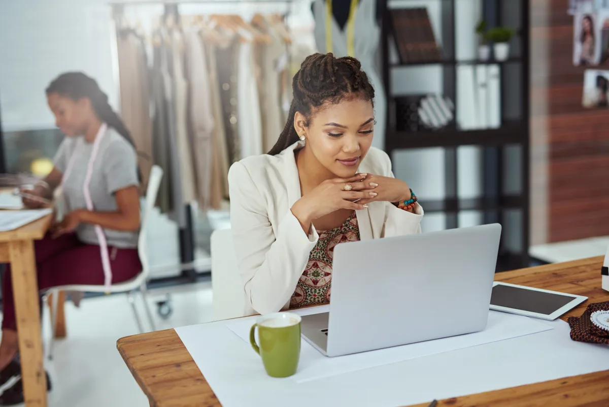 A small business owner reviewing customer feedback and ratings on a laptop at a workspace