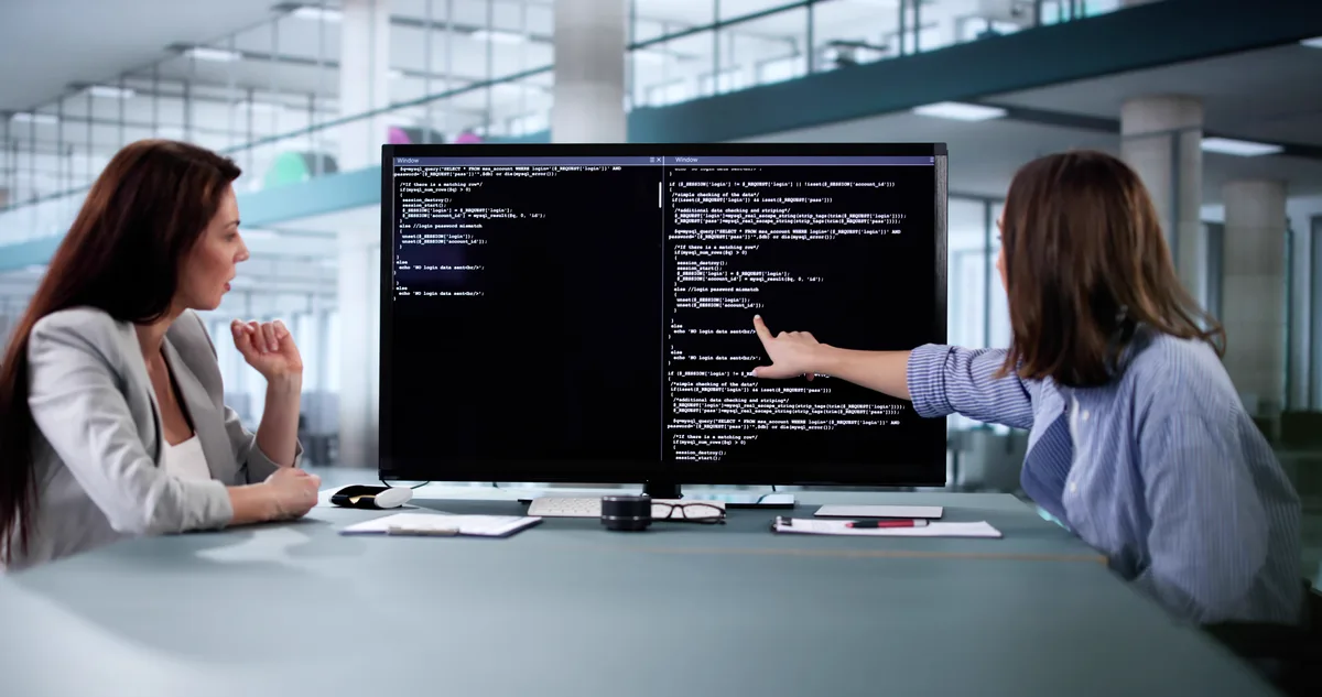 A web developer reviewing JSON-LD structured data and search results on a desktop screen while planning AI search visibility