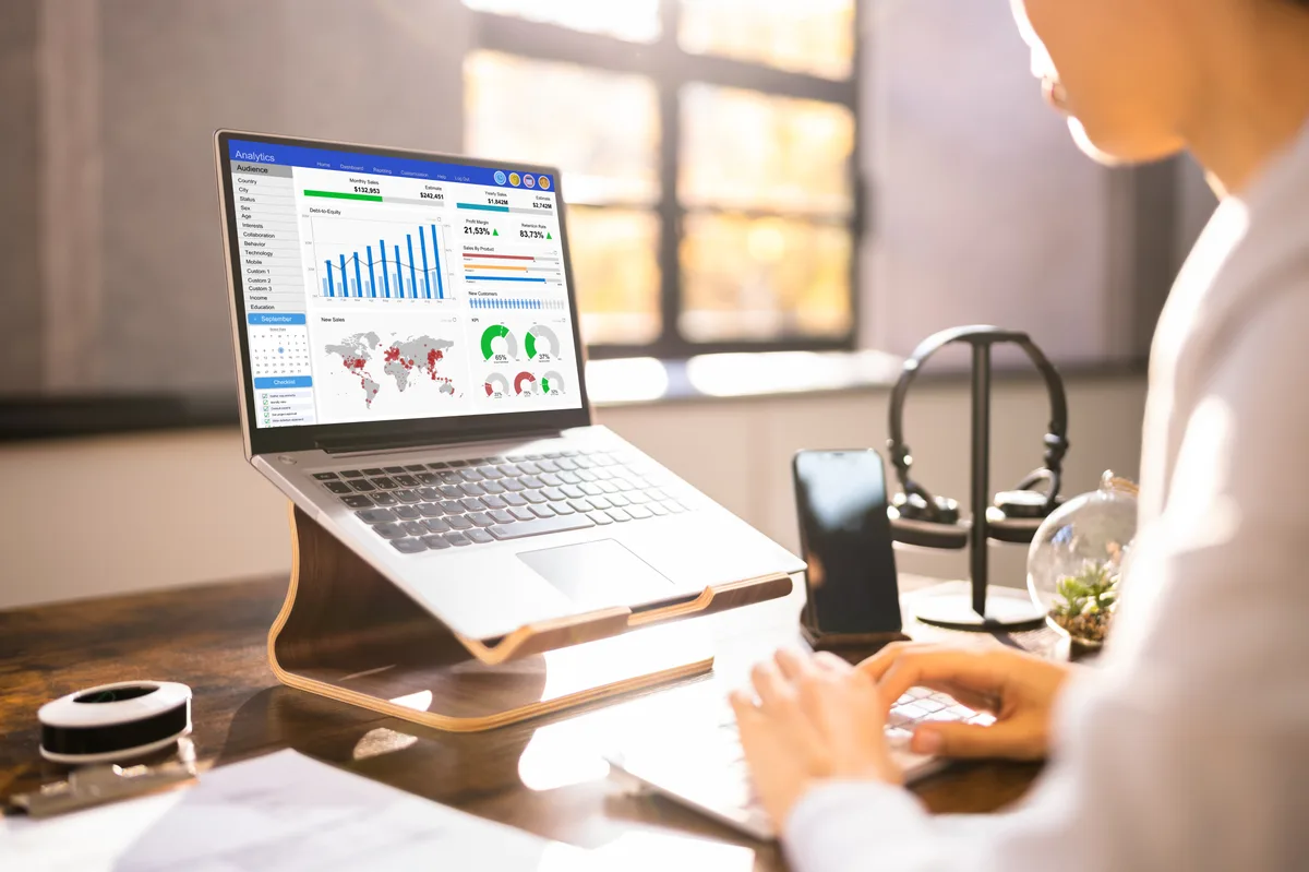 A business owner reviewing incoming website leads and follow-up sequences on a CRM dashboard on a laptop