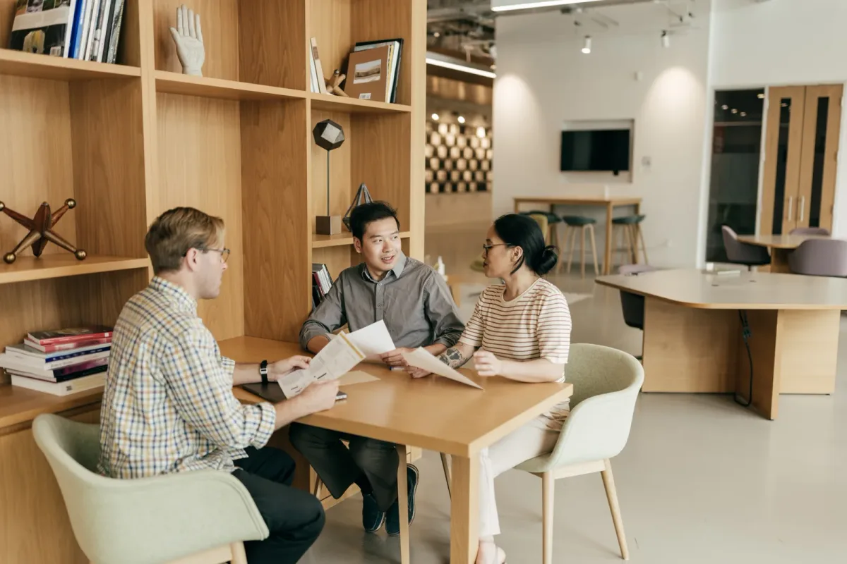 Loan officer explaining mortgage terms to a couple across a desk