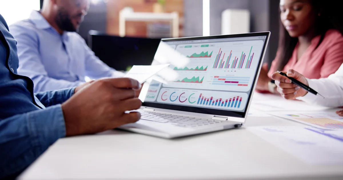 An e-commerce marketer reviewing a customer lifetime value and repeat-purchase dashboard on a laptop