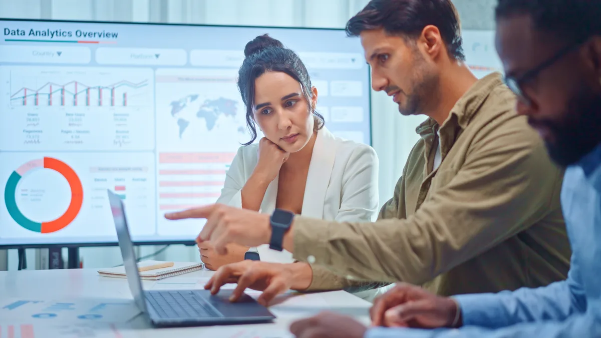 A marketer reviewing email campaign performance and revenue figures on a laptop dashboard