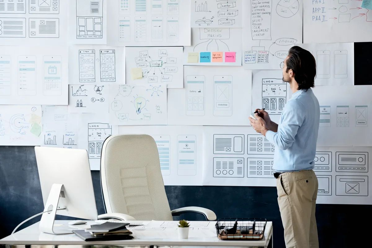 Marketing team mapping out a website content plan on a whiteboard covered in page topics