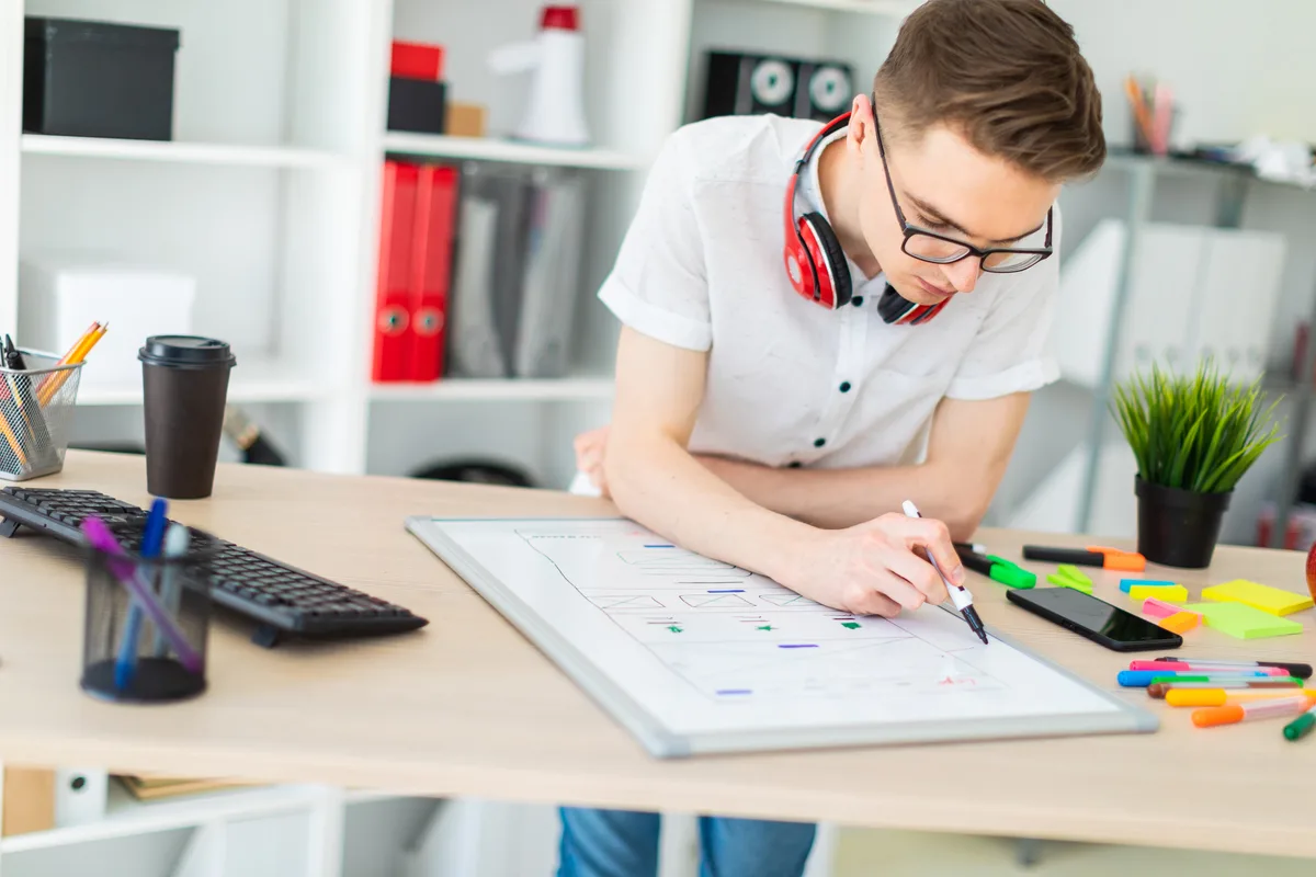 Web designer mapping out a website's page structure and navigation on a large desktop monitor