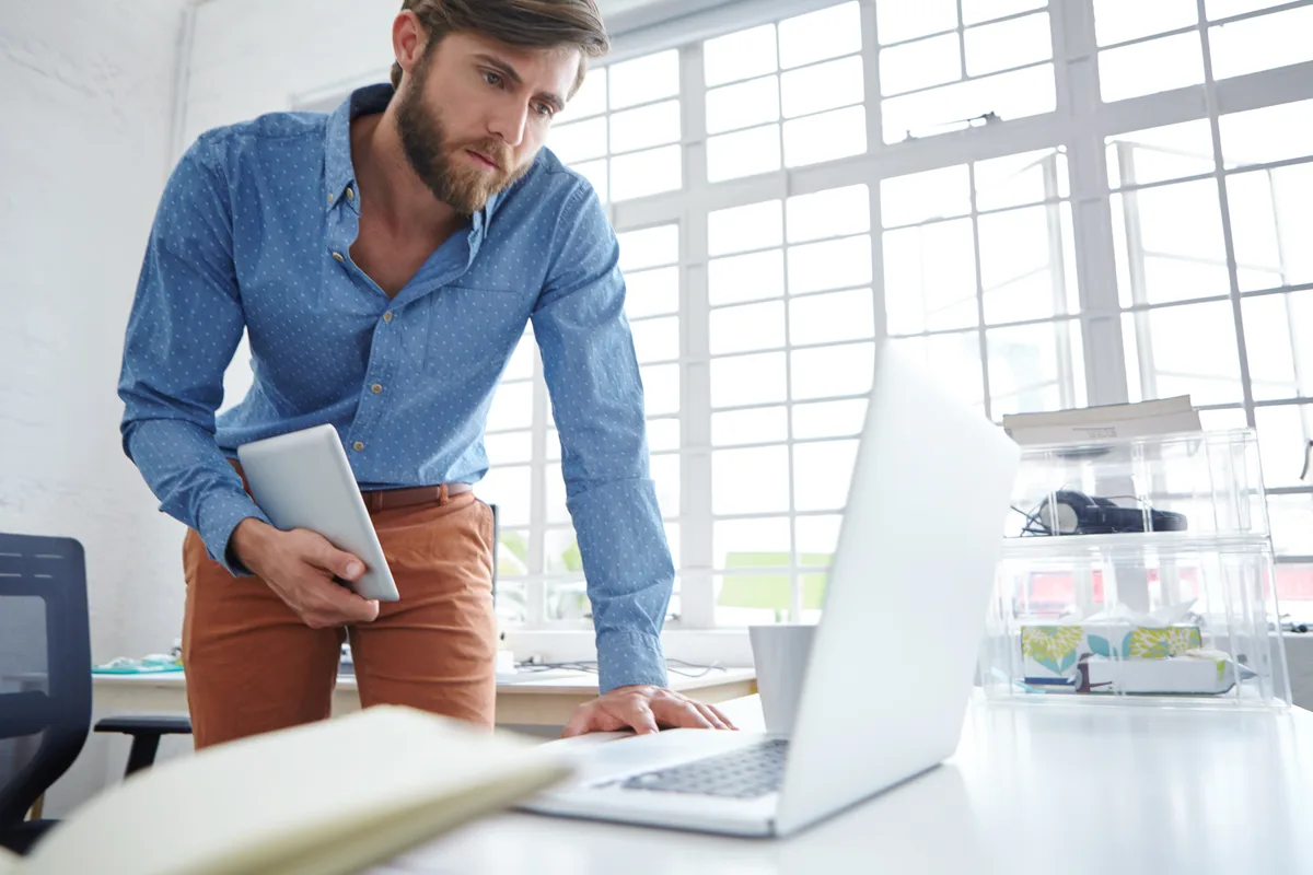 A business owner weighing whether to hire a GEO agency while reviewing AI search results on a laptop