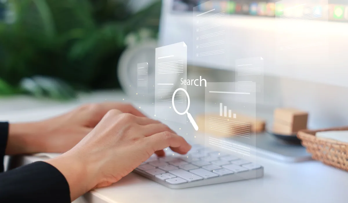 An SEO specialist reviewing organic traffic and keyword rankings on a large monitor while planning a monthly retainer workload