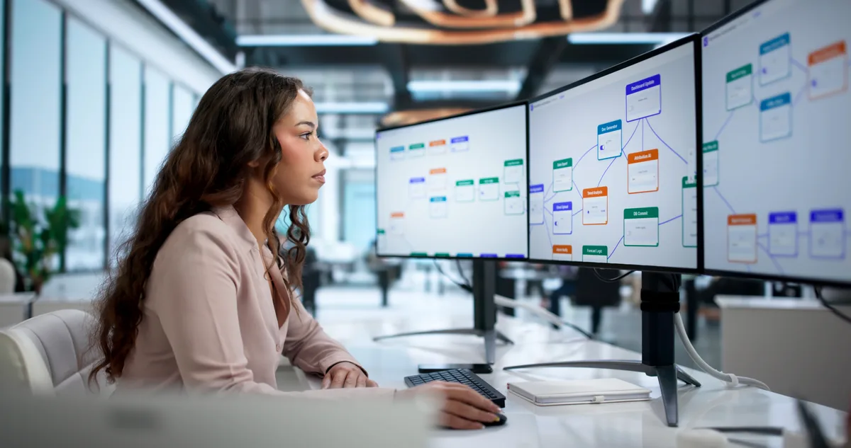 A marketing analyst reviewing ChatGPT and Perplexity answers side by side on dual monitors to audit a brand's AI visibility