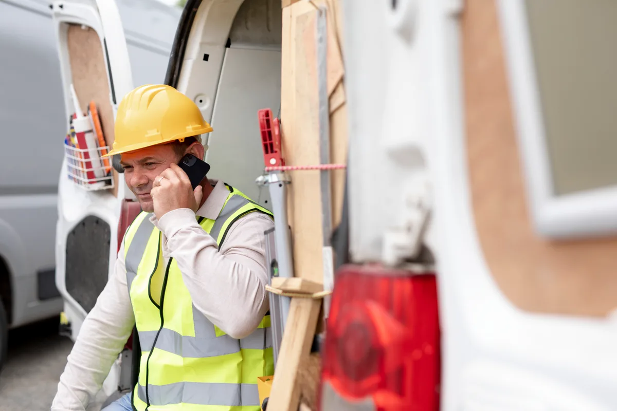 Home-service contractor taking a customer call beside a work van, the kind of phone lead Google Ads is meant to drive