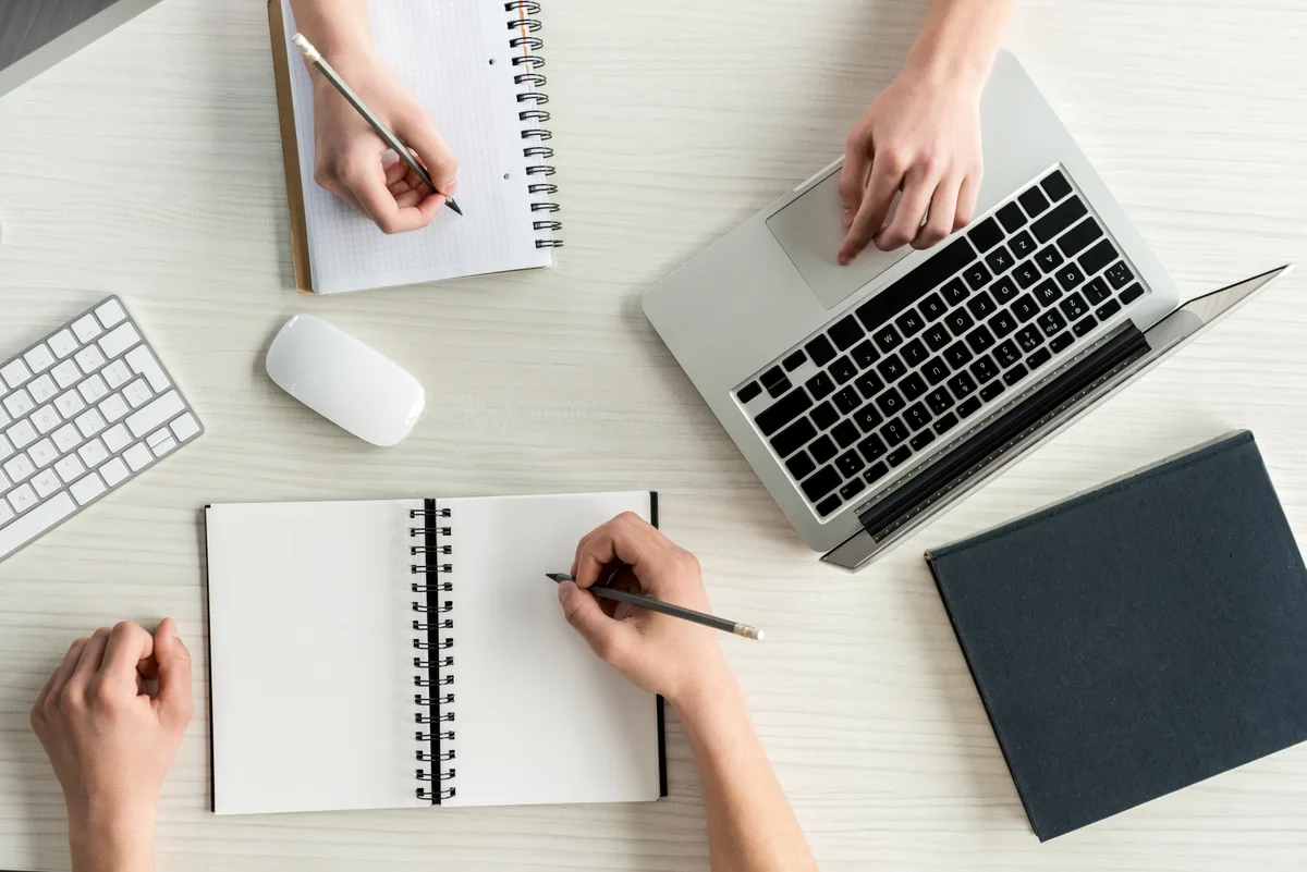 A copywriter and web designer reviewing page copy together on a laptop during a website redesign