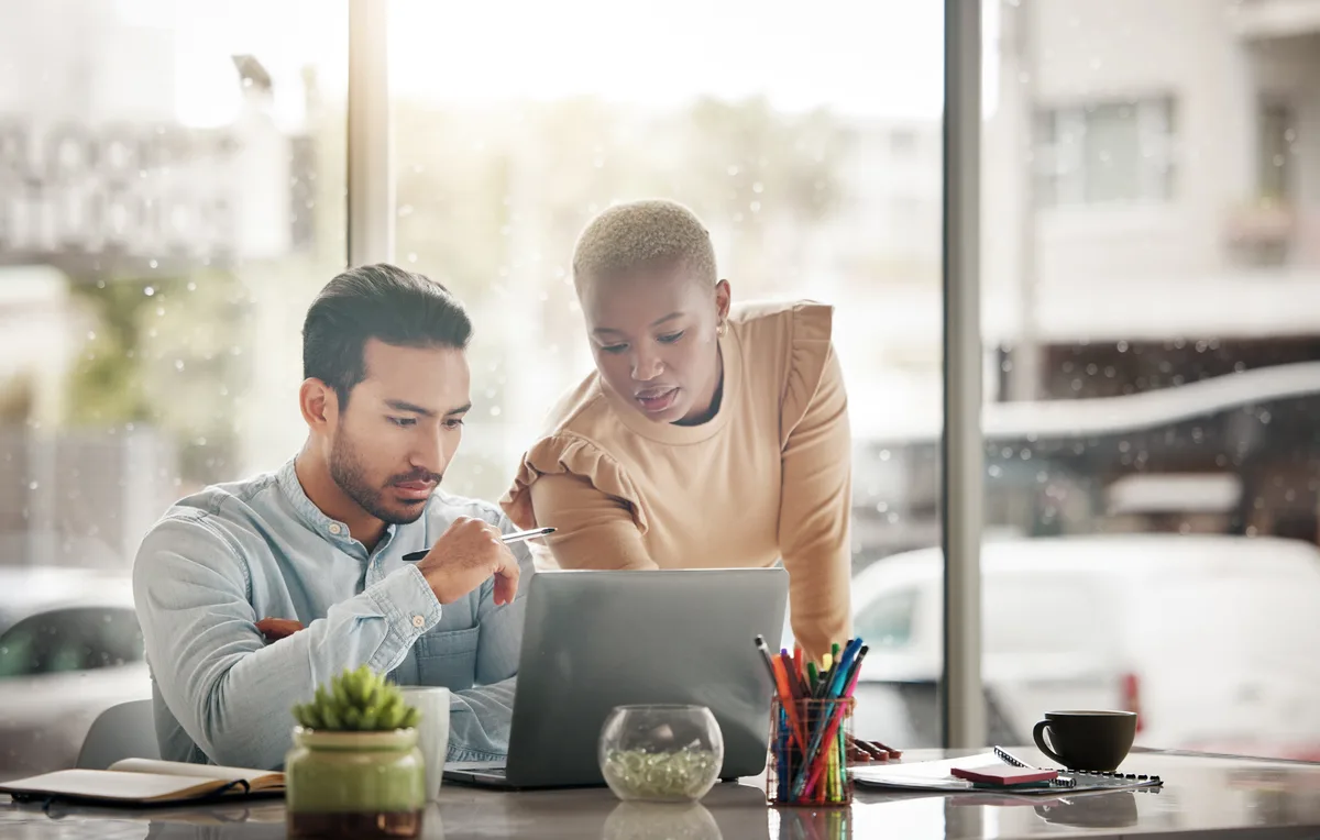 Business owner comparing a rival's plainer website to her own on a laptop, trying to understand the rankings gap