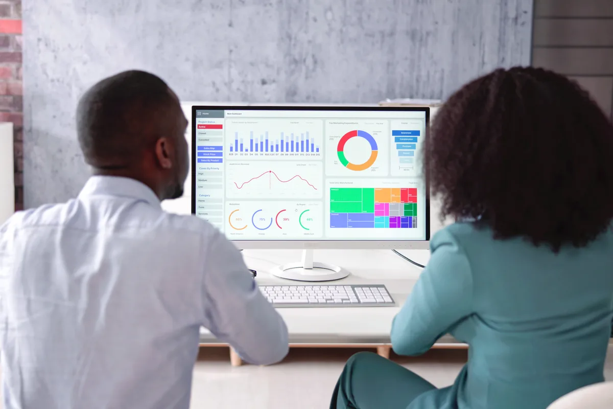 SEO specialist and business owner reviewing search ranking data for a new page on a desktop monitor