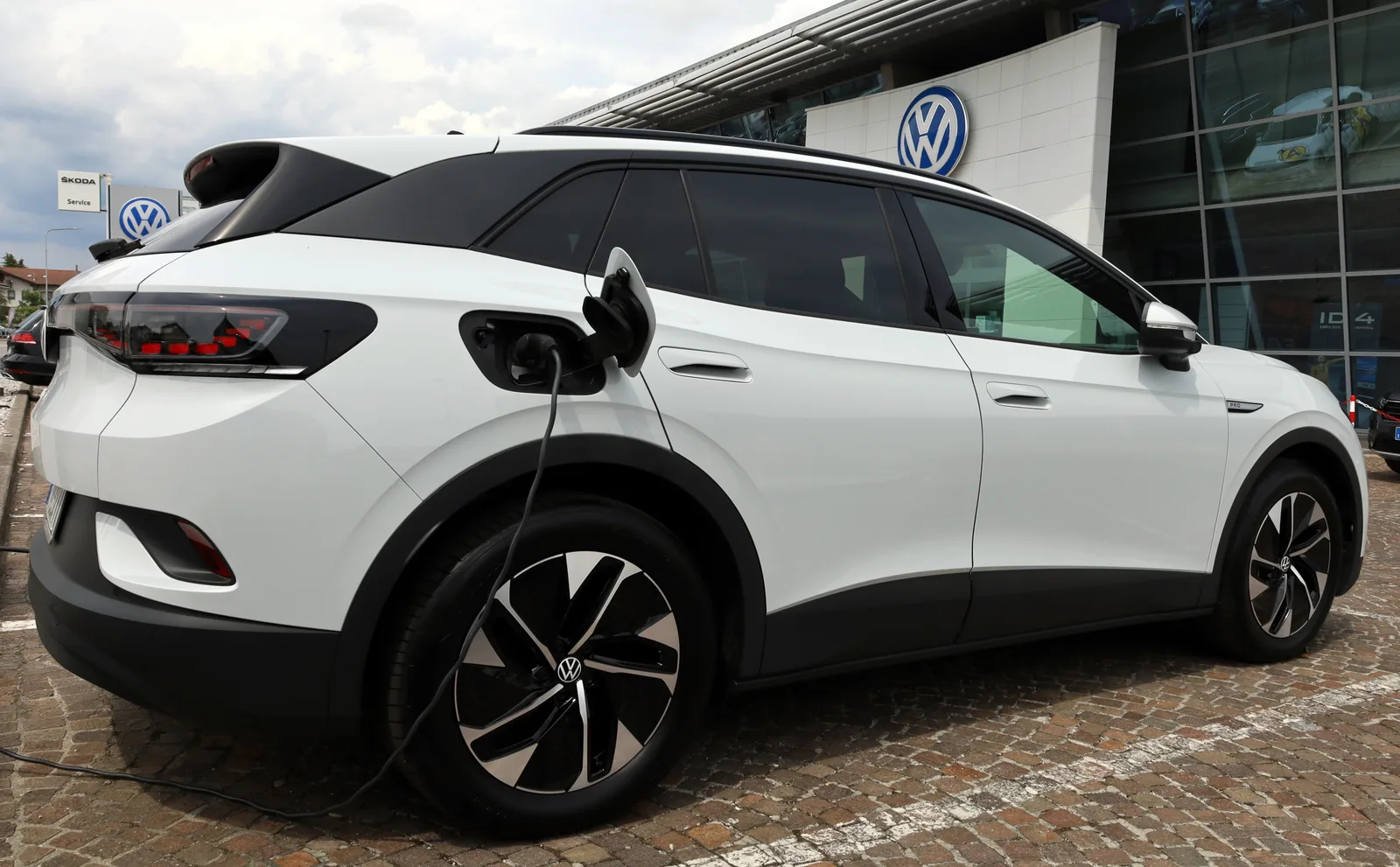 White 2026 Volkswagen ID.4 electric SUV charging outside the dealership