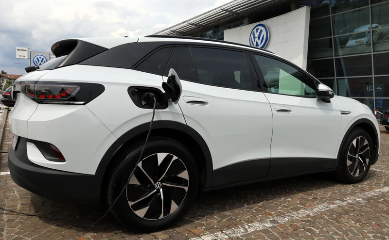 White 2026 Volkswagen ID.4 electric SUV charging outside the dealership