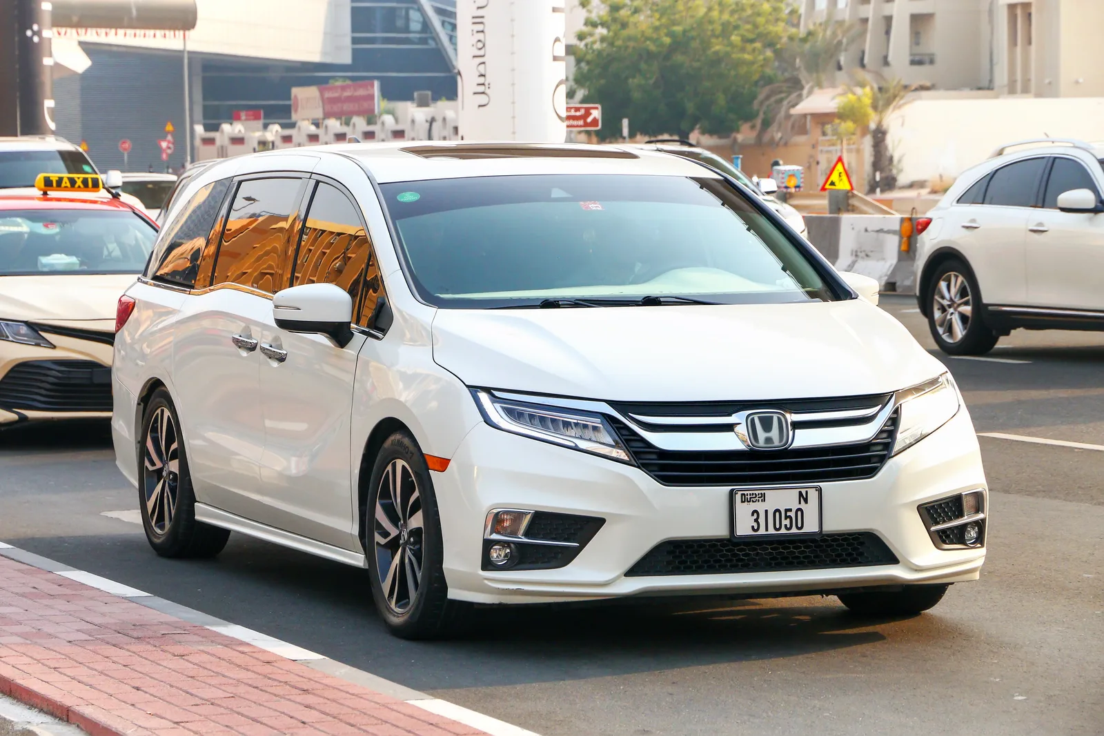 Pearl white Honda Odyssey Touring minivan, front three-quarter view