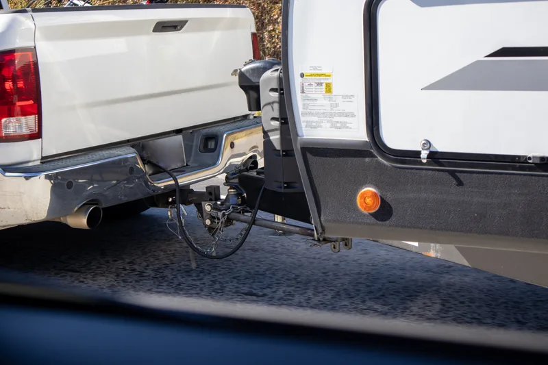 A white diesel pickup hitched to a travel trailer