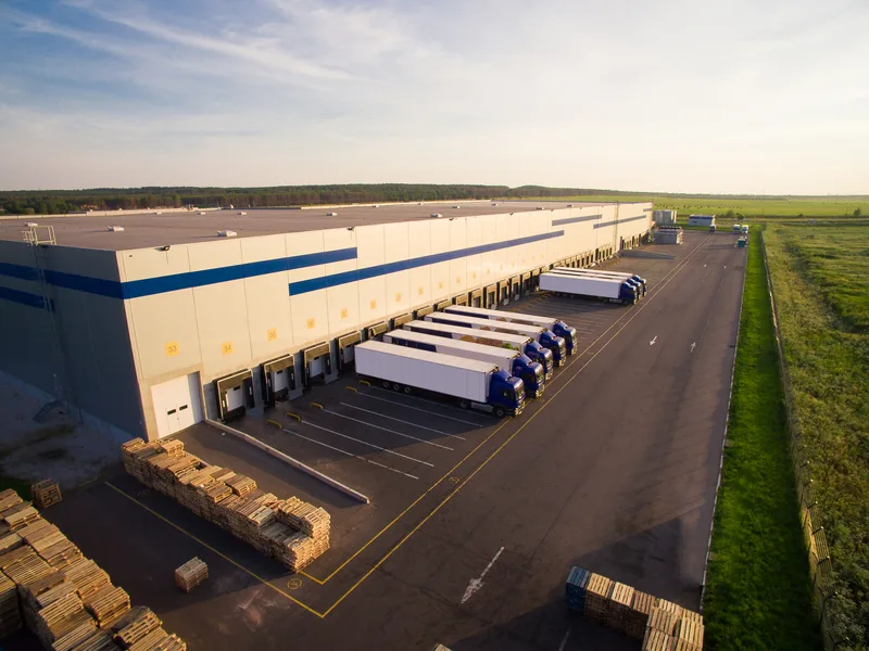 Aerial view of a distribution center yard with trailers backed into the docks