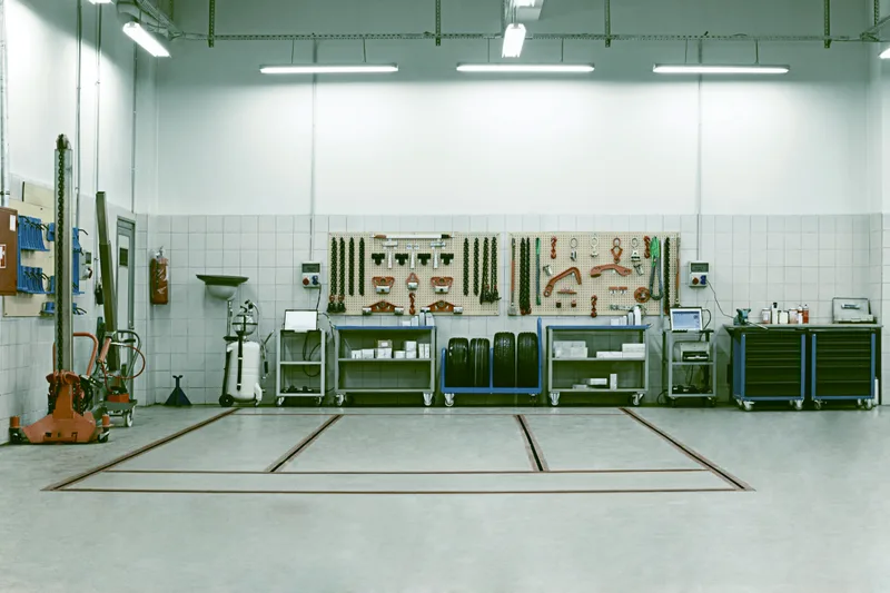 Clean, empty service bay with marked floor lines and a tidy tool wall
