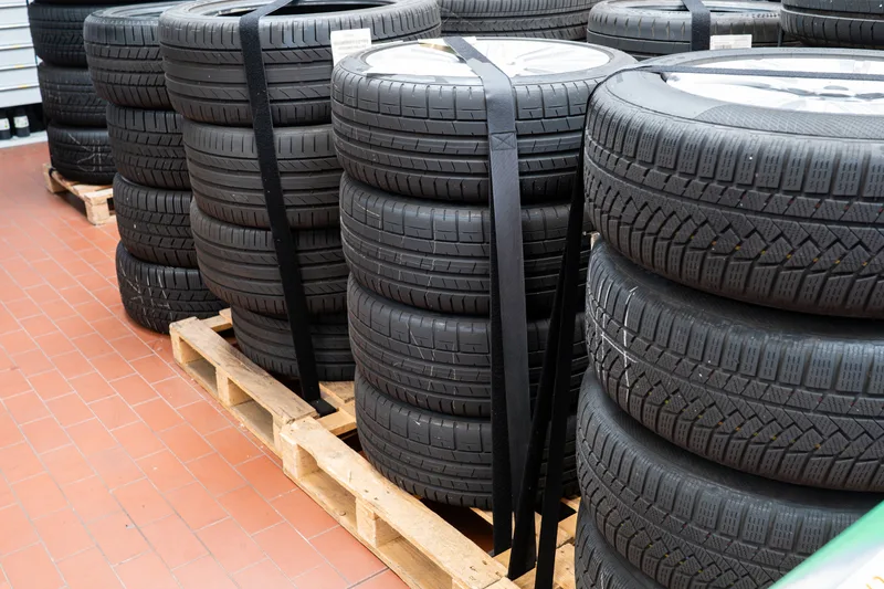 New tires stacked and strapped on pallets in the shop warehouse