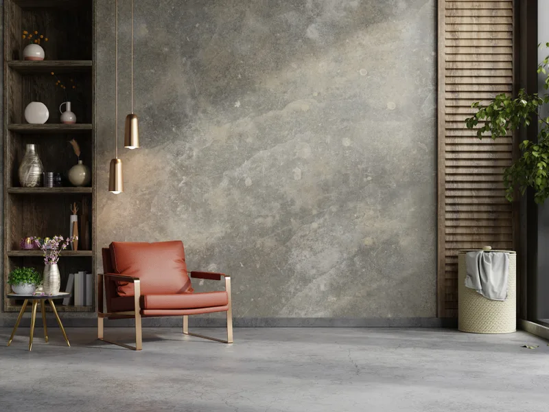 A calm front room with a rust leather armchair, open shelving and a plaster wall