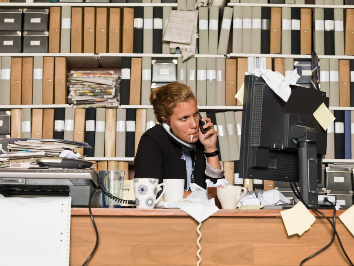 An admissions counselor wearing a headset speaking with a caller at a desk in a treatment center office