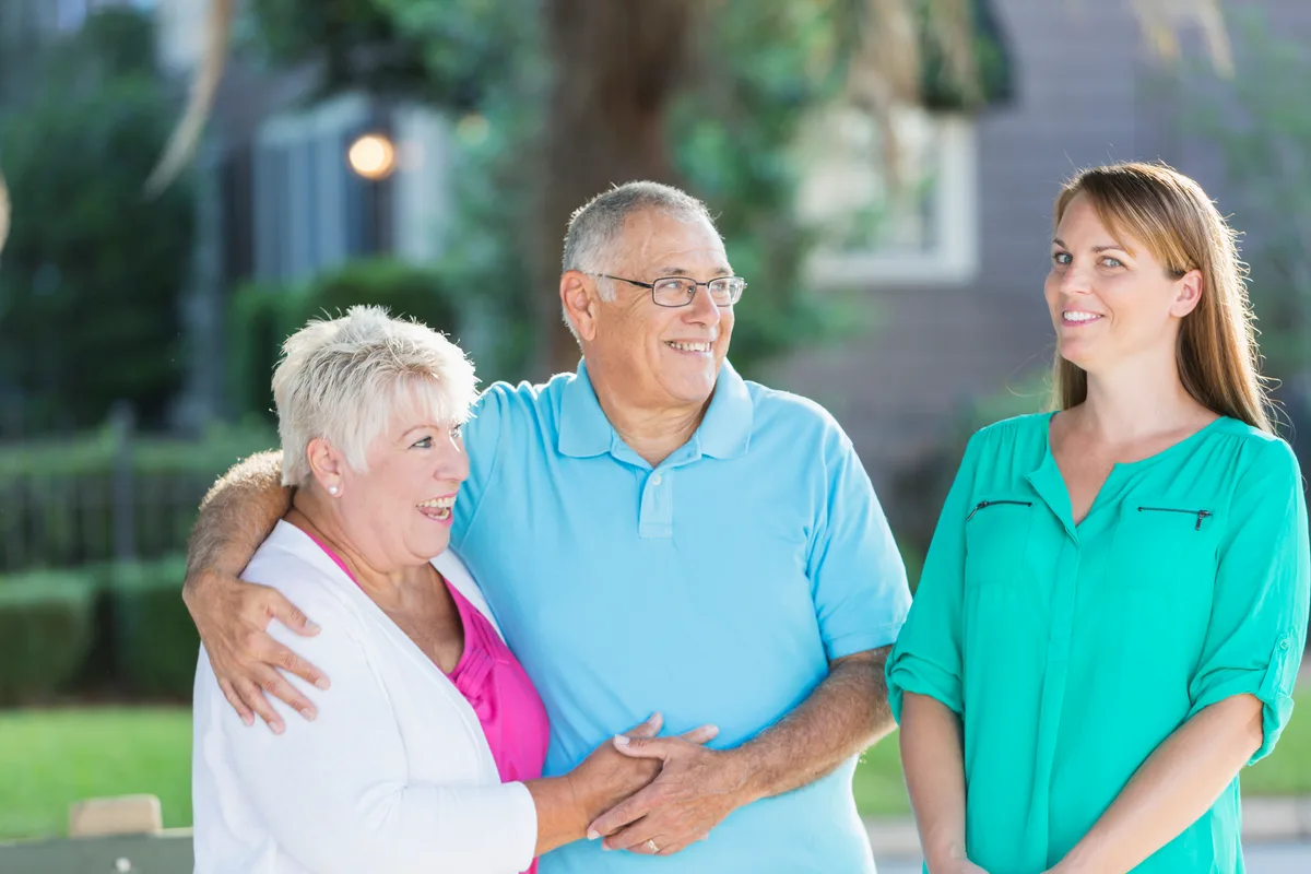 A senior-living advisor walking an adult daughter and her elderly mother through an assisted-living community during a tour