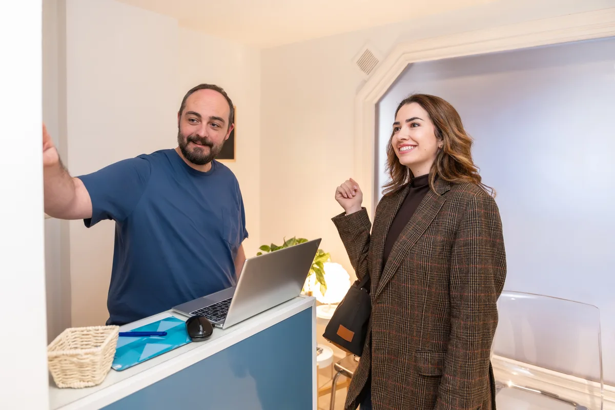 Chiropractor reviewing a treatment plan with a patient at a clinic reception desk