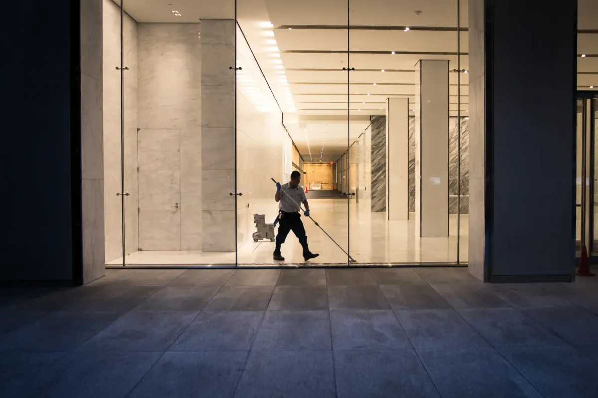 A commercial cleaner polishing an office building lobby floor after hours