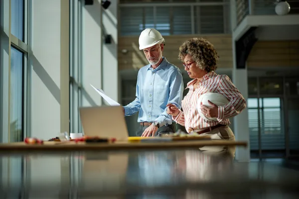 Commercial general contractor and project manager reviewing plans on site, the kind of buyer a marketing agency must understand