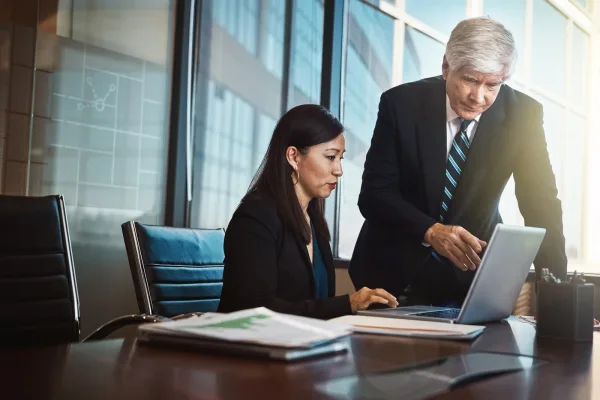 Commercial real estate asset manager and broker reviewing leasing and portfolio data together on a CRE software dashboard
