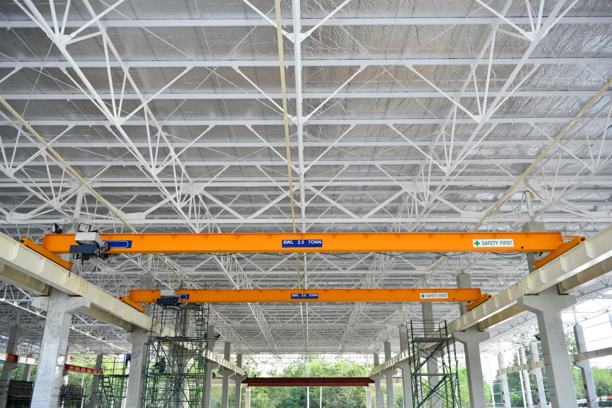 A mobile crane operator lifting a steel beam onto a commercial building under construction