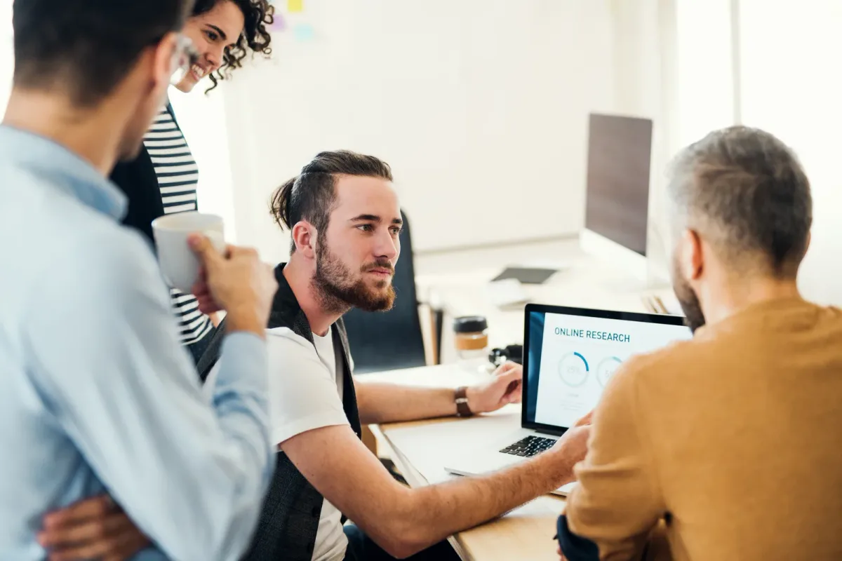 A digital publishing team reviewing traffic and content performance charts at a shared desk