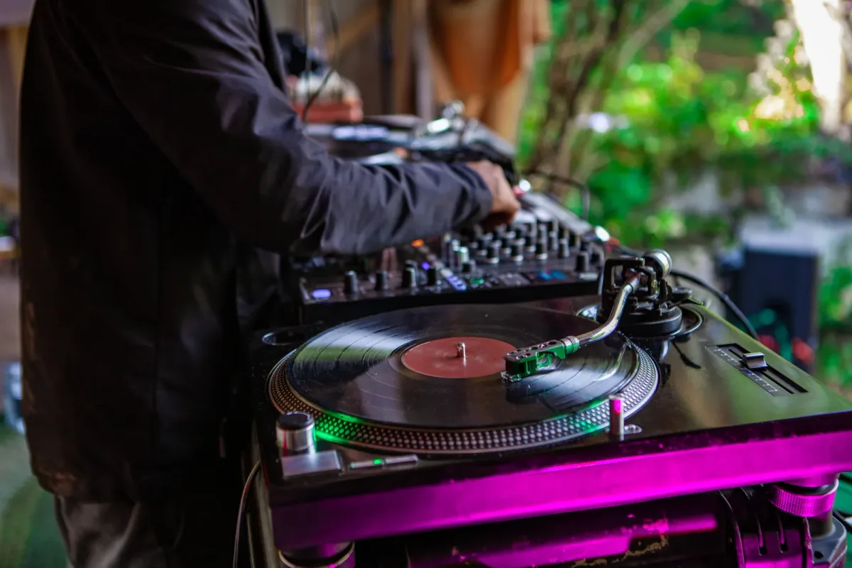 DJ mixing at a booth while guests fill the dance floor at a wedding reception