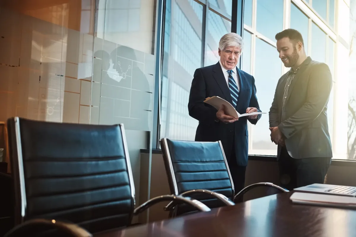 Employment defense attorney meeting with an HR director at a conference table reviewing an EEOC charge