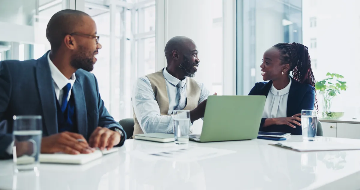 An employment lawyer reviewing documents with a client across a desk in a bright office